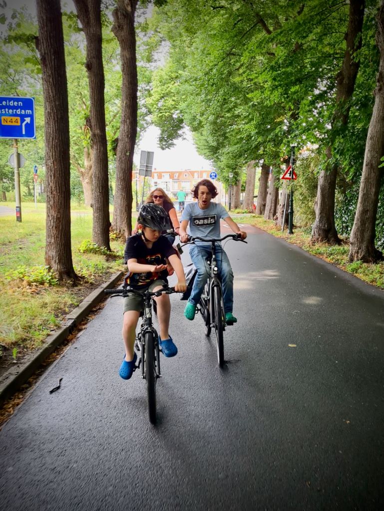 The family riding along, under the trees