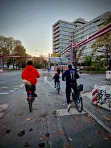 A family cycling at the Kurfürstenstraße junction, customary Berlin pink pipes