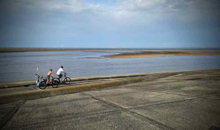 People cycling along the sea defences at Leasowe Lighthouse