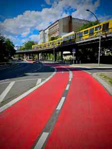 Red painted cycle lane next to U-Bahn viaduct on Bülowstraße