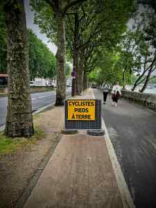 Cyclists dismount sign on the cycle path on Avenue de New York