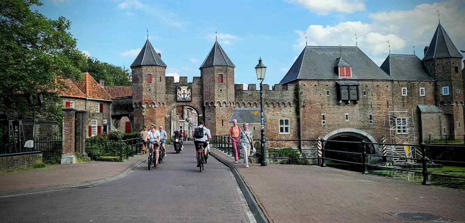 People cycling through the gate at Koppelpoort