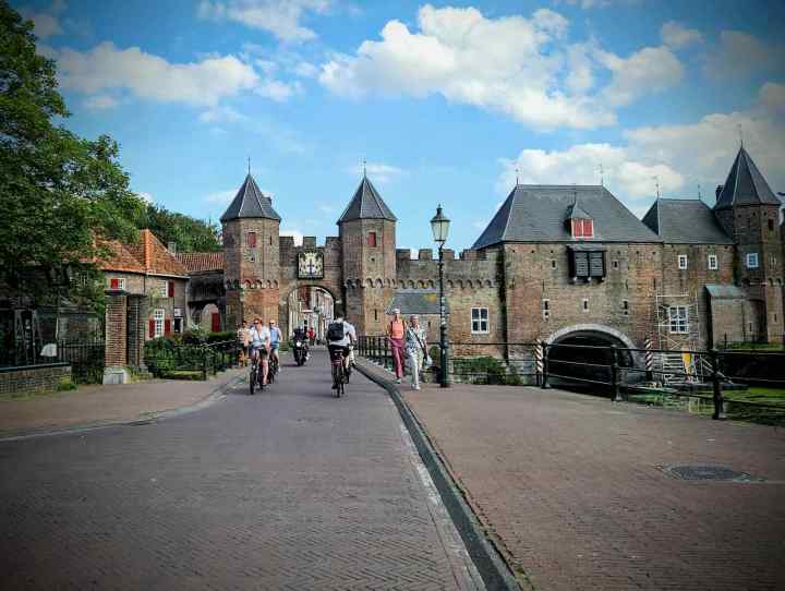 People cycling through the gate at Koppelpoort