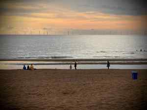 Looking out to sea, people on the beach