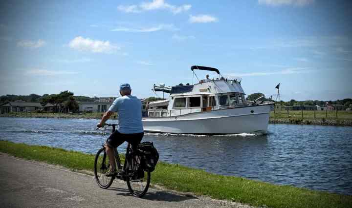 Man cycling past a boat on the Vliet Canal