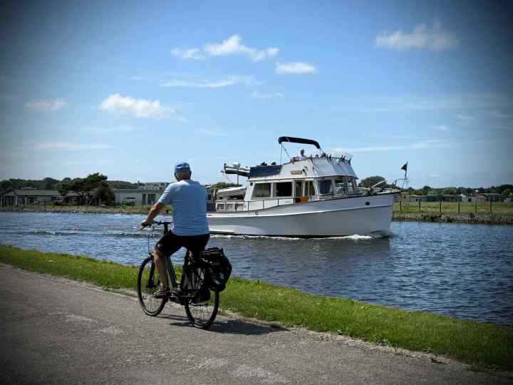 Man cycling past a boat on the Vliet Canal