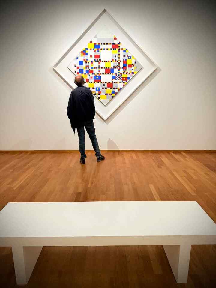 Person in front of Victory Boogie Woogie by Piet Mondrian